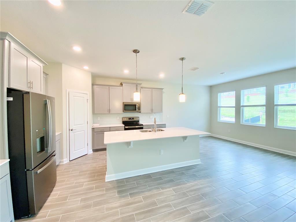 2768 Norway Maple Court Ocoee, FL 34761 - Photo 6 of 35 a view of kitchen with kitchen island a sink wooden floor and stainless steel appliances