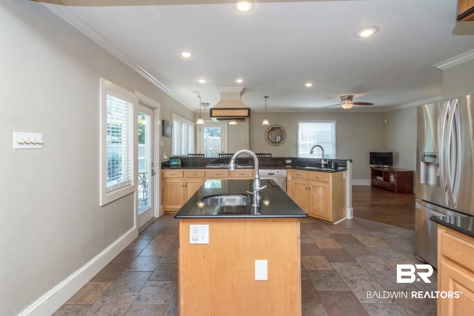 116 Florence Place Mobile, AL 36607 - Photo 12 of 41 Kitchen featuring stainless steel refrigerator with ice dispenser, dark tile patterned floors, light brown cabinets, and a kitchen island with sink