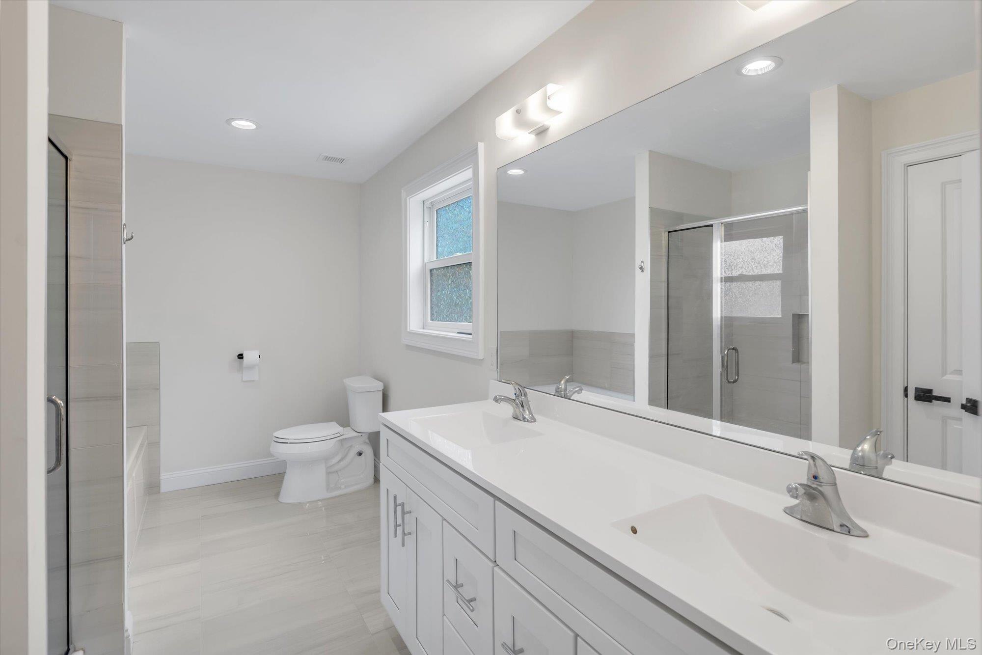 135 Elizabeth Way Ridge, NY 11961 - Photo 12 of 24 a bathroom with a sink a toilet and a mirror
