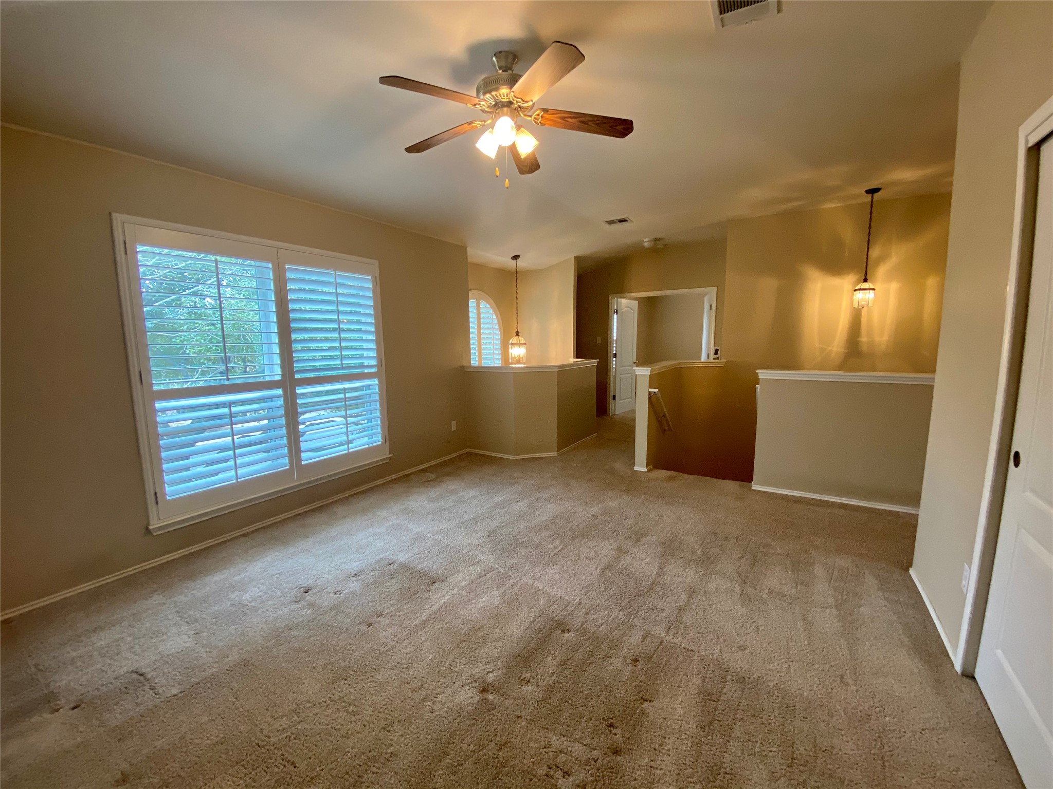 4615 Tello Path Austin, TX 78749 - Photo 15 of 29 A versatile open-concept space featuring comfortable carpeting and adjustable window shutters.