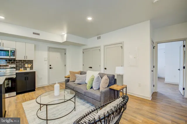 a living room with furniture and kitchen view