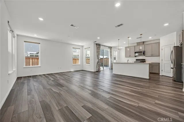 a view of a kitchen with a sink and dishwasher a refrigerator with wooden floor