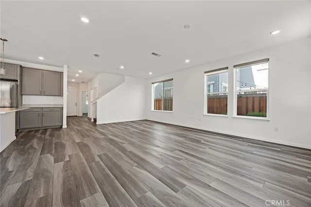 a view of empty room with wooden floor and windows