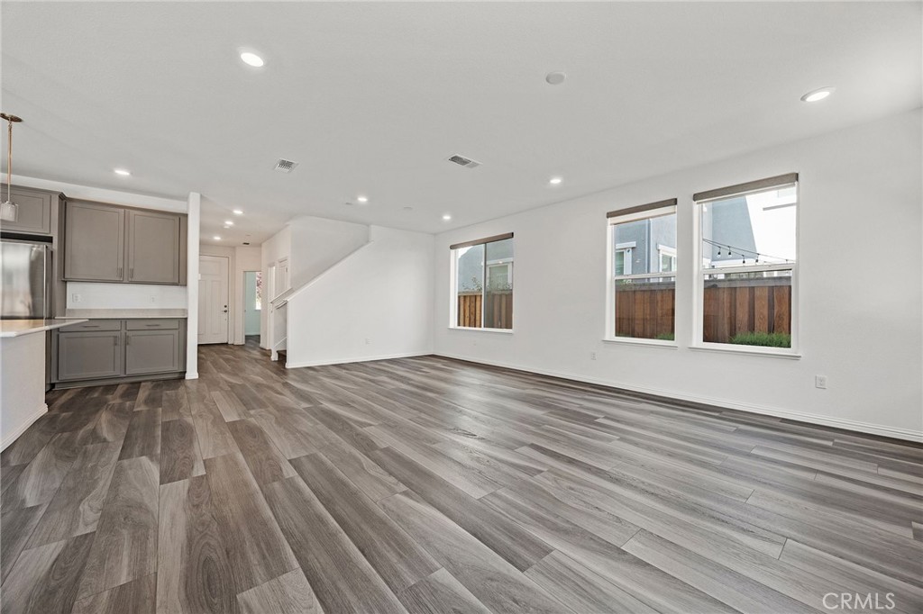 237 Goose Creek Avenue Brentwood, CA 94513 - Photo 6 of 49 a view of empty room with wooden floor and windows