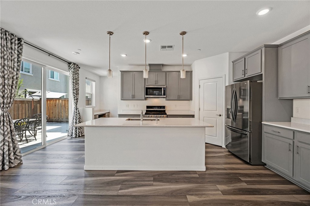 237 Goose Creek Avenue Brentwood, CA 94513 - Photo 8 of 49 a large kitchen with stainless steel appliances refrigerator a stove and wooden floor
