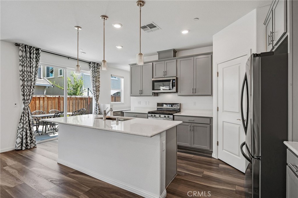 237 Goose Creek Avenue Brentwood, CA 94513 - Photo 9 of 49 a kitchen with kitchen island white cabinets and stainless steel appliances