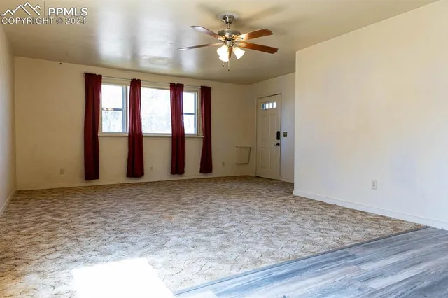 a view of a livingroom with a ceiling fan and window