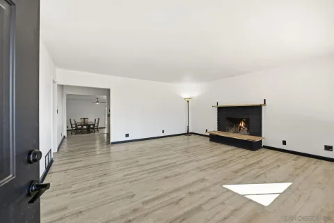 a view of a livingroom with wooden floor and a fireplace