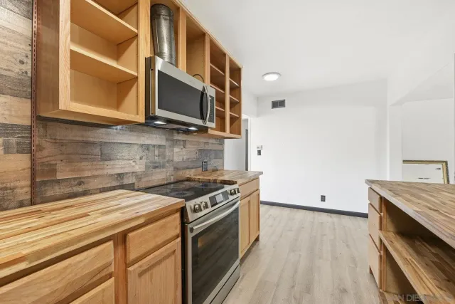 a kitchen with stainless steel appliances granite countertop a stove and a microwave