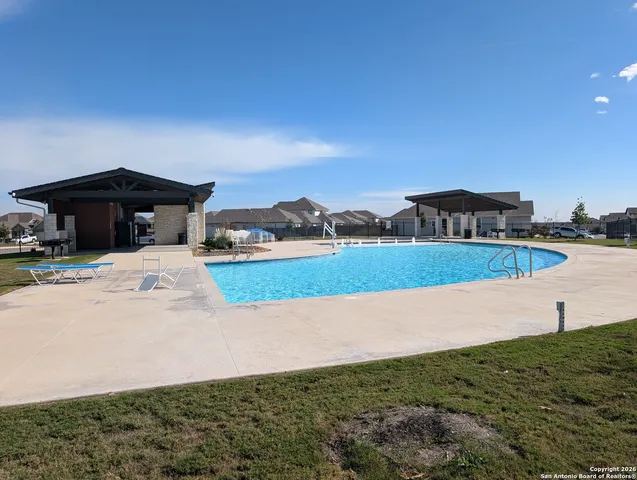 a swimming pool with lots of tress in the background
