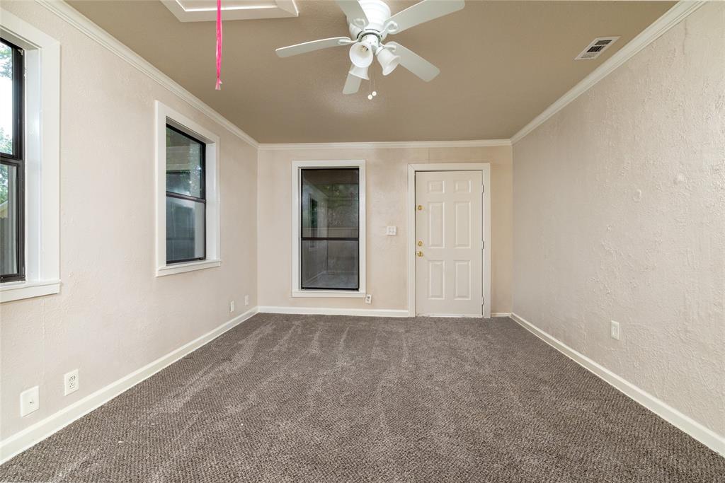 313 North Roe Street White Settlement, TX 76108 - Photo 20 of 33 Neutral-toned room featuring a textured wall finish, white trim, and a ceiling fan with integrated lighting