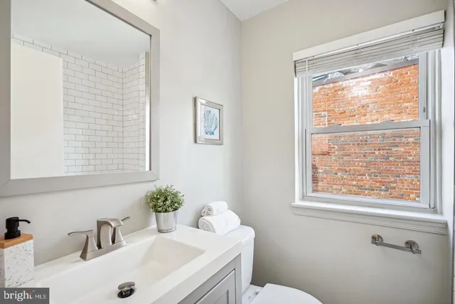 a bathroom with a sink a toilet and a window