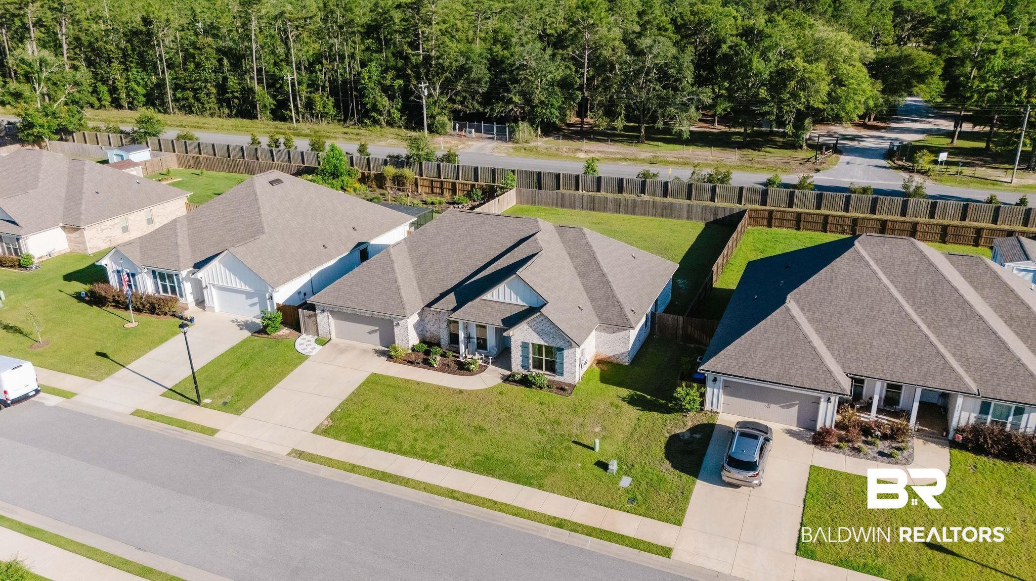 7872 Calverton Street Foley, AL 36535 - Photo 70 of 76 Aerial perspective of a neighborhood street with multiple single-story homes featuring light-toned siding and dark shingle roofs