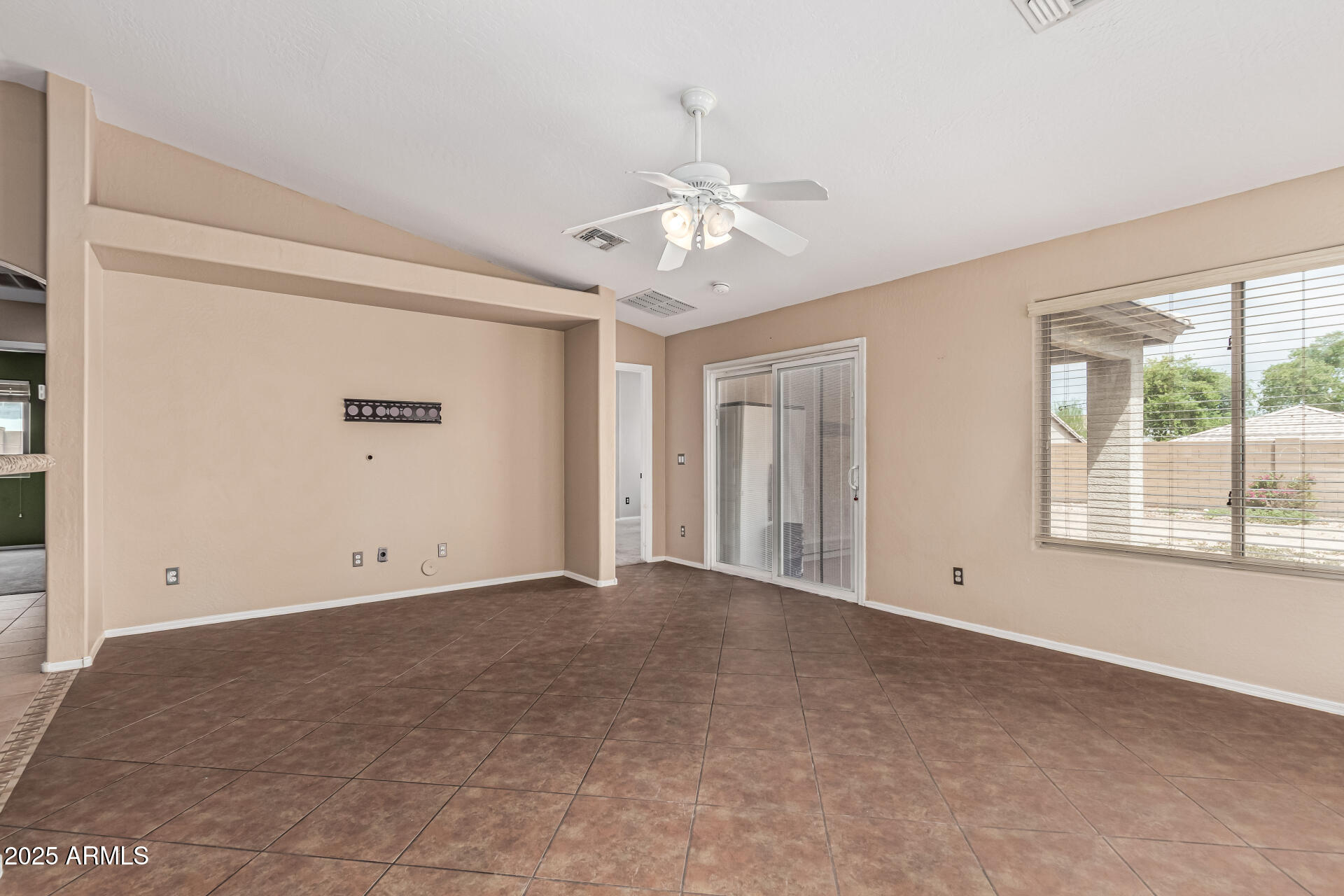 1634 East Harwell Road Phoenix, AZ 85042 - Photo 8 of 44 an empty room with windows and chandelier fan