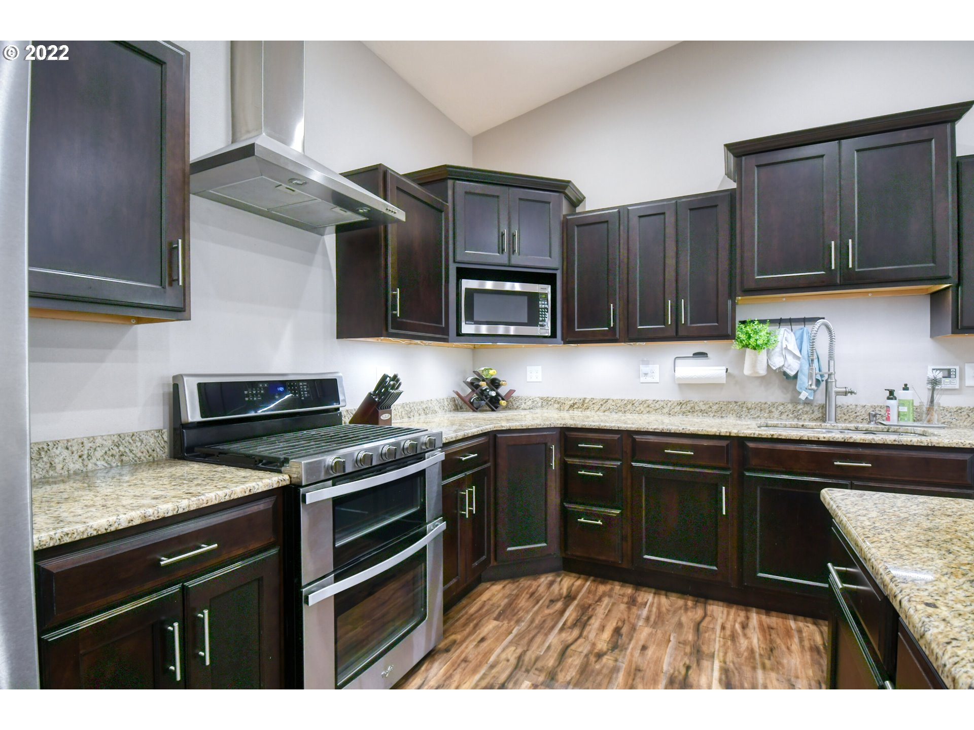 1803 Southwest 3rd Street Pendleton, OR 97801 - Photo 11 of 32 a kitchen with stainless steel appliances granite countertop wooden cabinets a stove top oven a sink and dishwasher