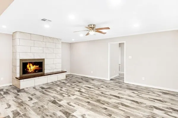 a view of a room with a fireplace ceiling fan and window