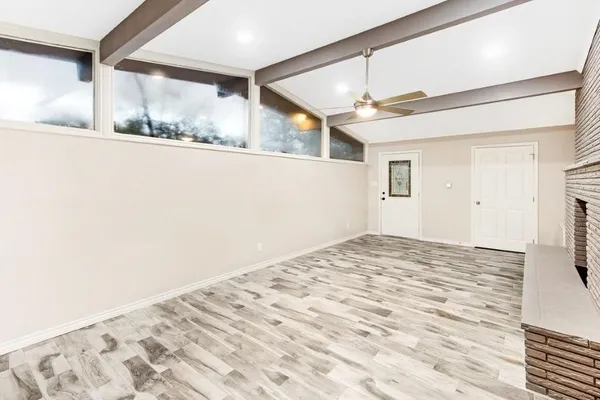 a view of a big room with wooden floor and windows