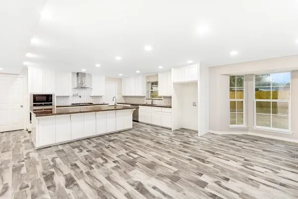 a large kitchen with kitchen island a sink stainless steel appliances and cabinets