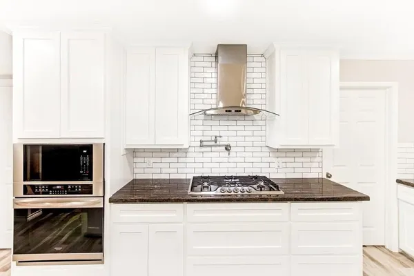 a kitchen with cabinets and white stove