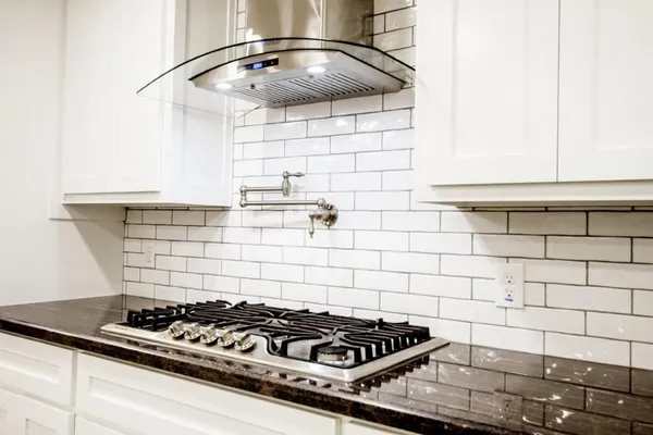 a stove top oven sitting inside of a kitchen