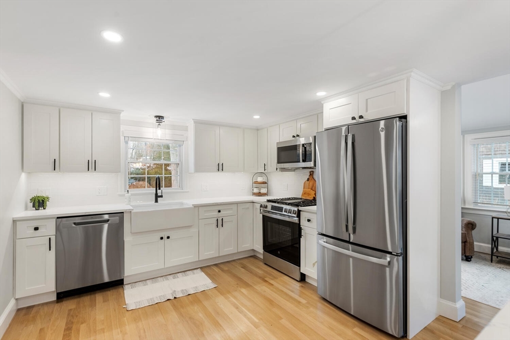 53 Perkins Street Stoneham, MA 02180 - Photo 11 of 34 a kitchen with white cabinets and stainless steel appliances