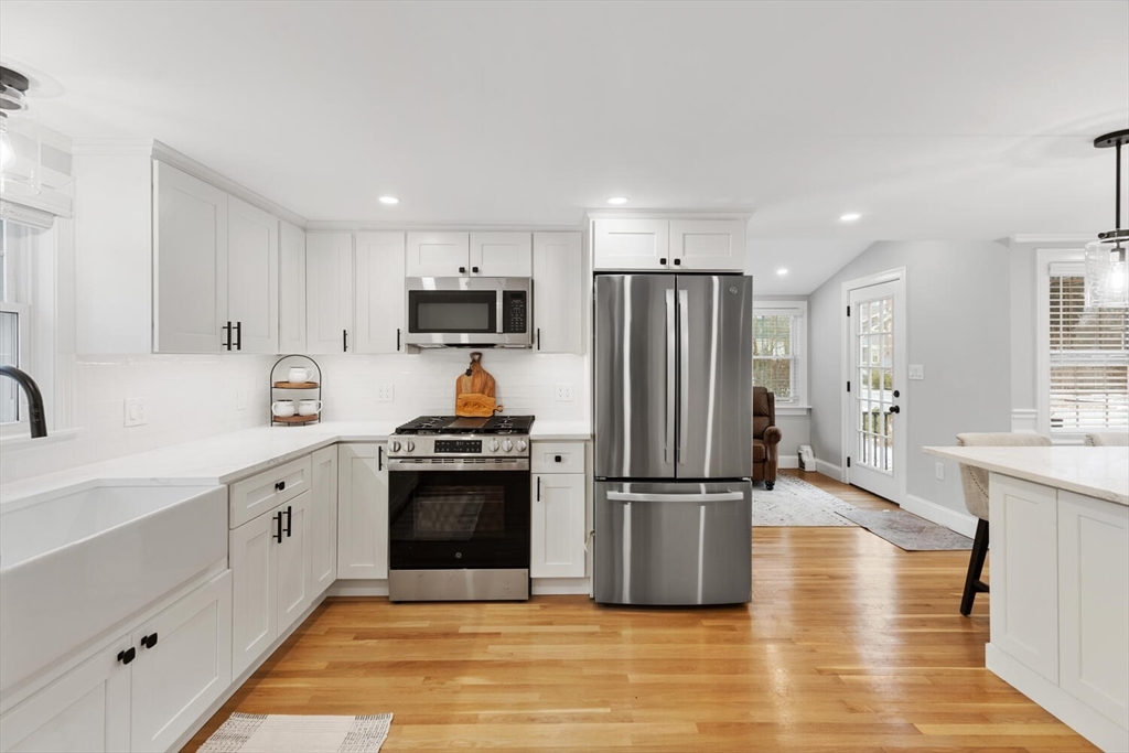 53 Perkins Street Stoneham, MA 02180 - Photo 12 of 34 a kitchen with cabinets stainless steel appliances and wooden floor