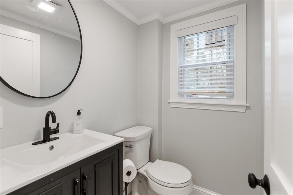 53 Perkins Street Stoneham, MA 02180 - Photo 21 of 34 a bathroom with a toilet a sink a mirror and vanity