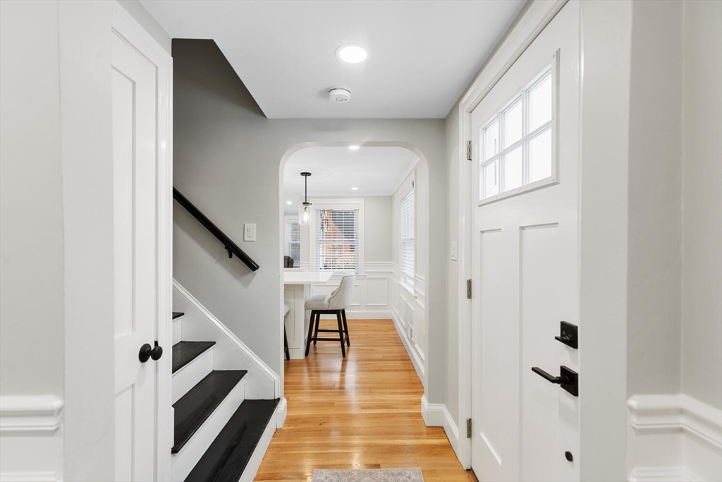 53 Perkins Street Stoneham, MA 02180 - Photo 8 of 34 a view of a hallway with white walls and wooden floor