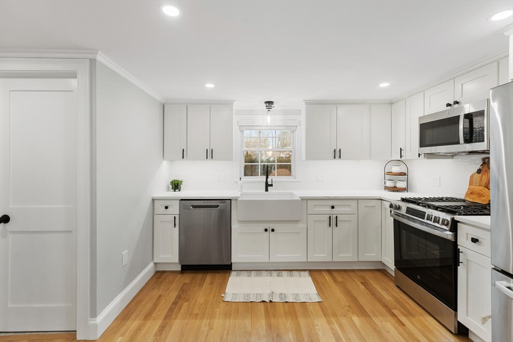 53 Perkins Street Stoneham, MA 02180 - Photo 10 of 34 a kitchen with cabinets stainless steel appliances a sink and wooden floor