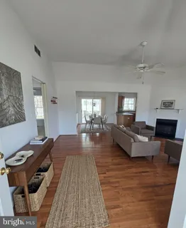 a view of empty room with wooden floor and fireplace