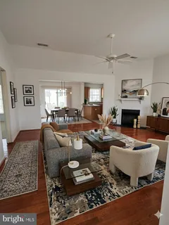a kitchen with stainless steel appliances granite countertop a stove top oven a sink a dining table and chairs with wooden floor