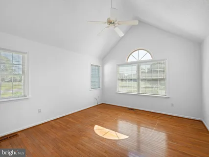 an empty room with a ceiling fan and a window