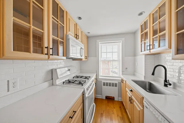 a kitchen with stainless steel appliances a stove a sink a refrigerator and cabinets