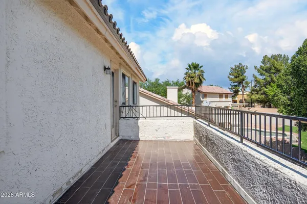a view of an empty room with wooden floor and a ceiling fan