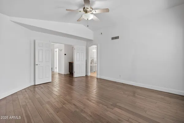 a view of an empty room with wooden floor and staircase
