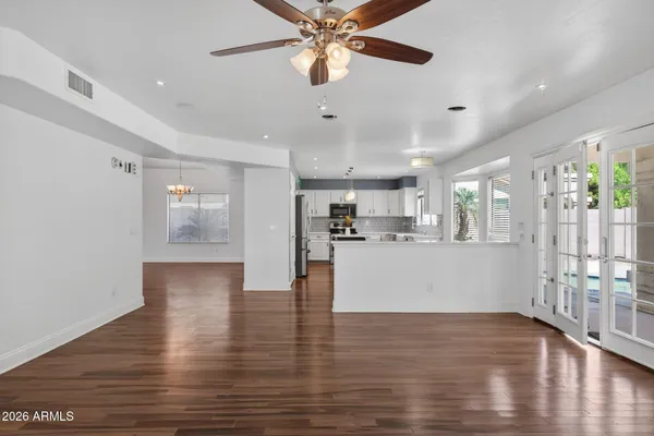 a view of a kitchen with wooden floor and a ceiling fan