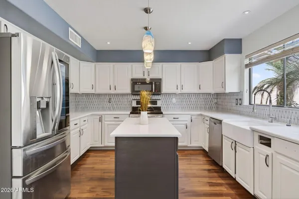 a kitchen with granite countertop a refrigerator stove top oven and sink