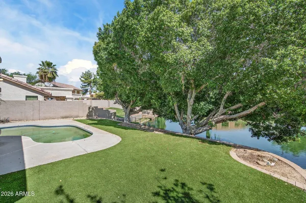 a view of a house with backyard and trees