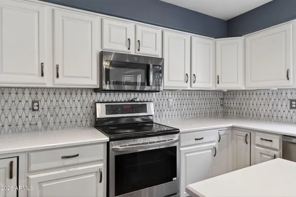 a kitchen with a sink dishwasher a stove a refrigerator and cabinets with wooden floor