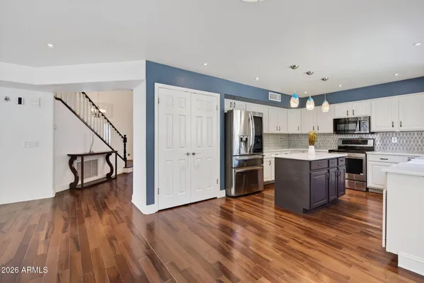 an empty room with wooden floor fireplace and windows