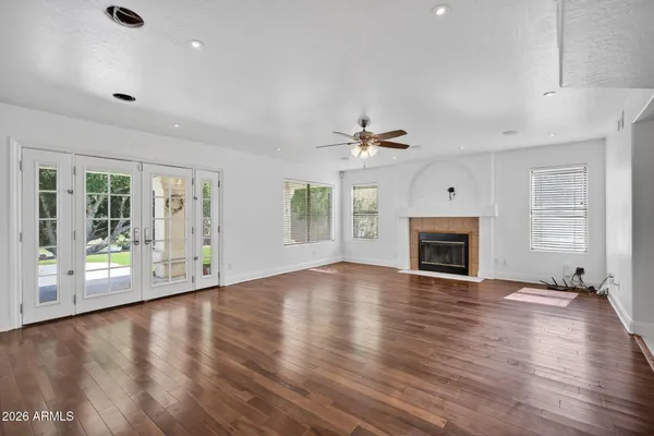 a view of an empty room with a window and wooden floor