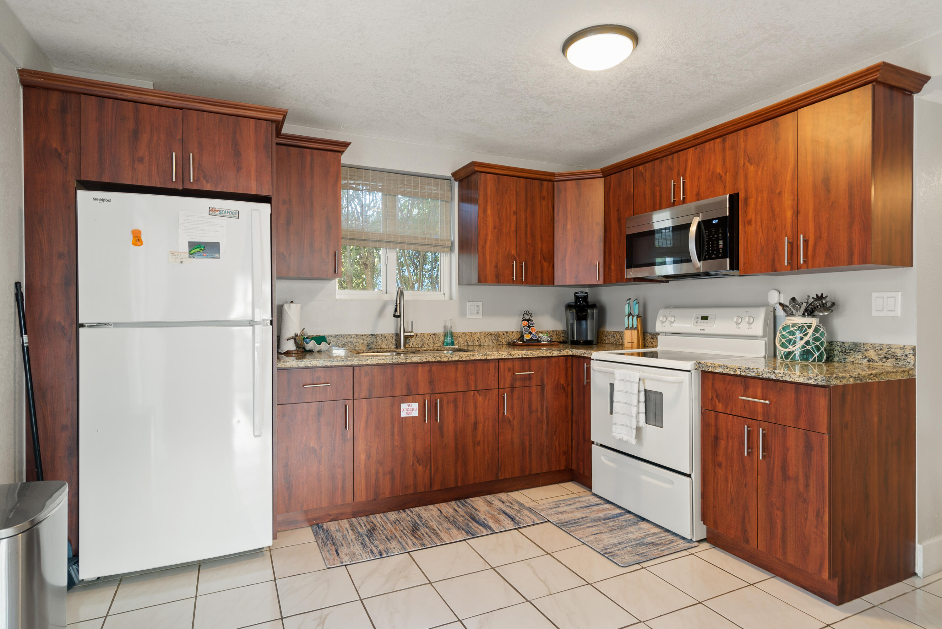 127 Seaside Avenue Key Largo, FL 33037 - Photo 25 of 50 a kitchen with a refrigerator sink and cabinets