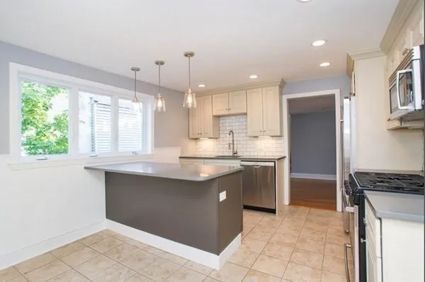 a kitchen with kitchen island granite countertop a sink and a stove