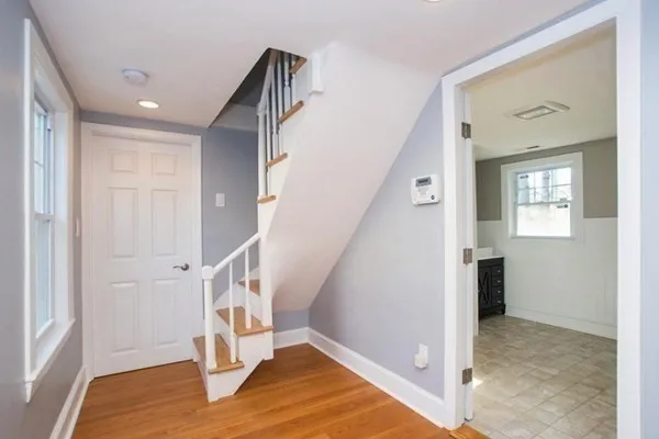a view of entryway and hall with wooden floor