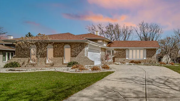 a front view of a house with a garden and yard