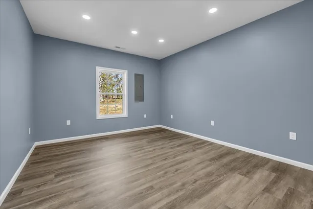 a view of an empty room with wooden floor