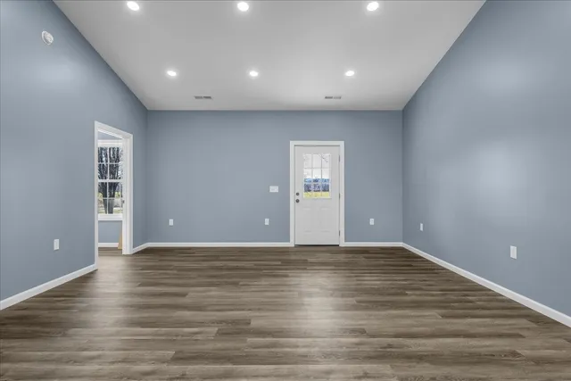 a view of an empty room with wooden floor