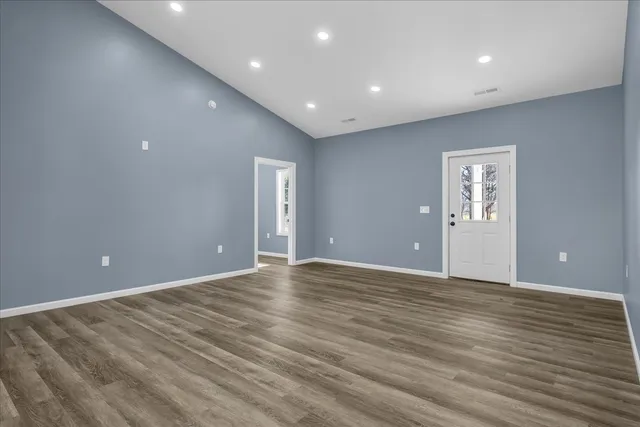 a large kitchen with kitchen island granite countertop wooden floors and a sink