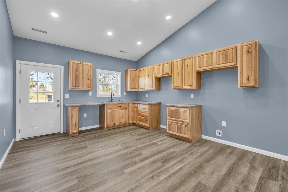 191 Tiffany Lane Decherd, TN 37324 - Photo 7 of 37 a large kitchen with kitchen island granite countertop wooden floors and a sink