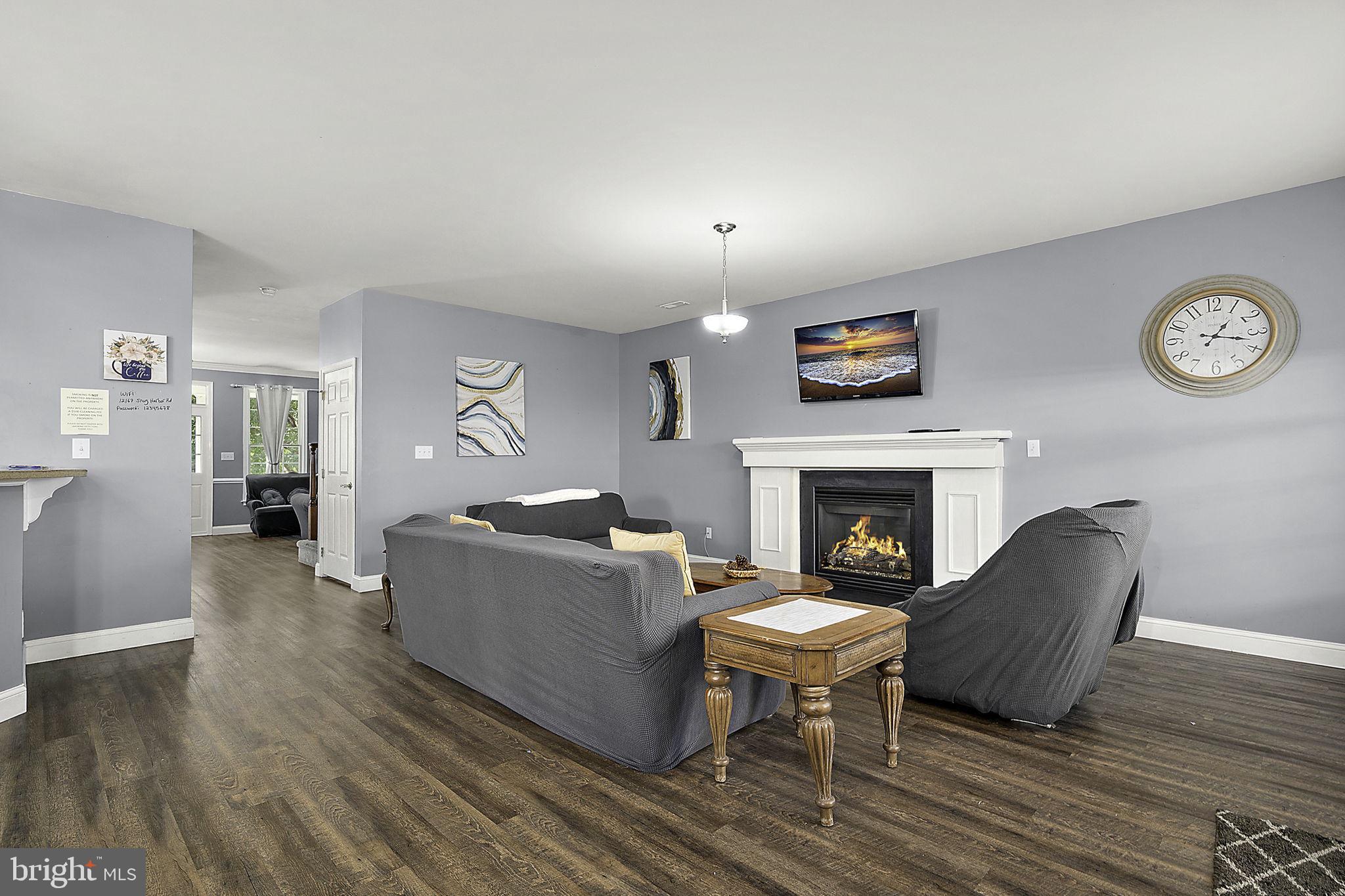 12167 Snug Harbor Road Berlin, MD 21811 - Photo 20 of 107 a living room with furniture a fireplace and a table